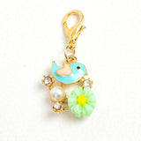 Blue Enamel Bird with pink heart shaped wing, green resin flower, rhinestones and acrylic pearl with light gold lobster claw clasp