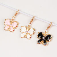 Enamel butterfly charm with rhinestone accent in pink, white or black. 